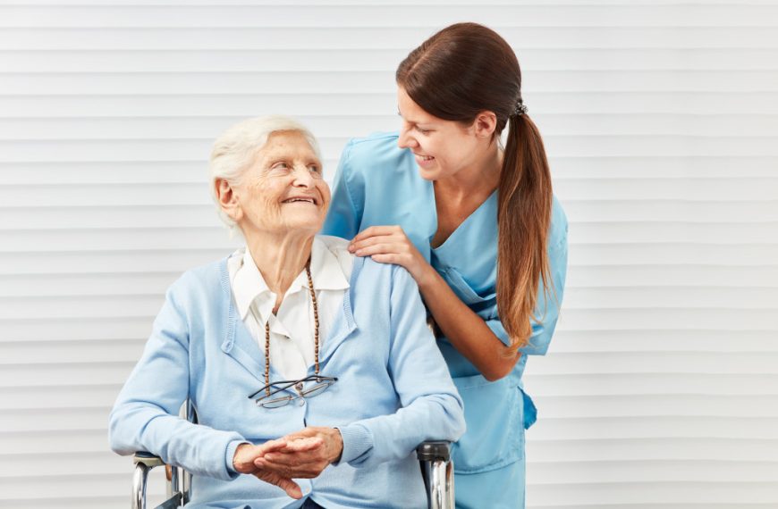 health care provider leaning on a shoulder of a senior in a wheelchair