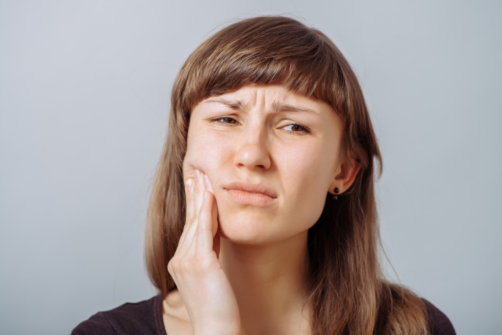 A woman feeling symptoms of gum disease
