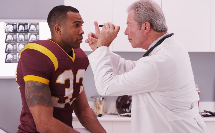 a male athlete getting checked out by doctor