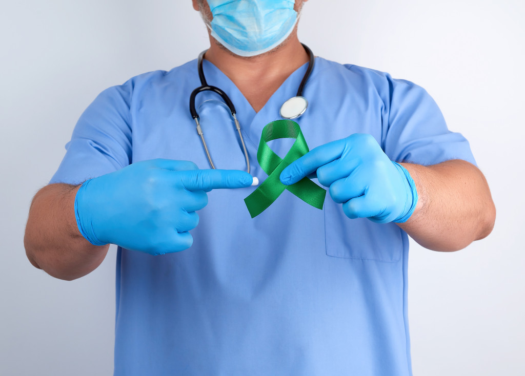 medical practitioner pointing to a green ribbon representing lyme disease
